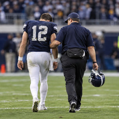 coach walking quarterback off the field
