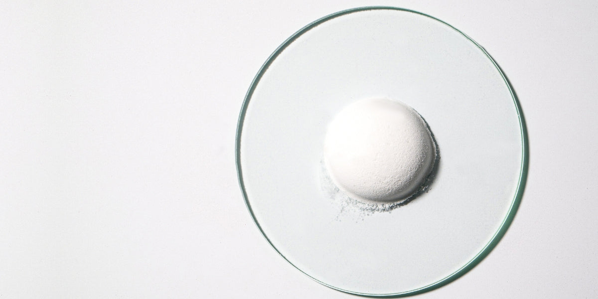 Creatine powder displayed in laboratory glassware